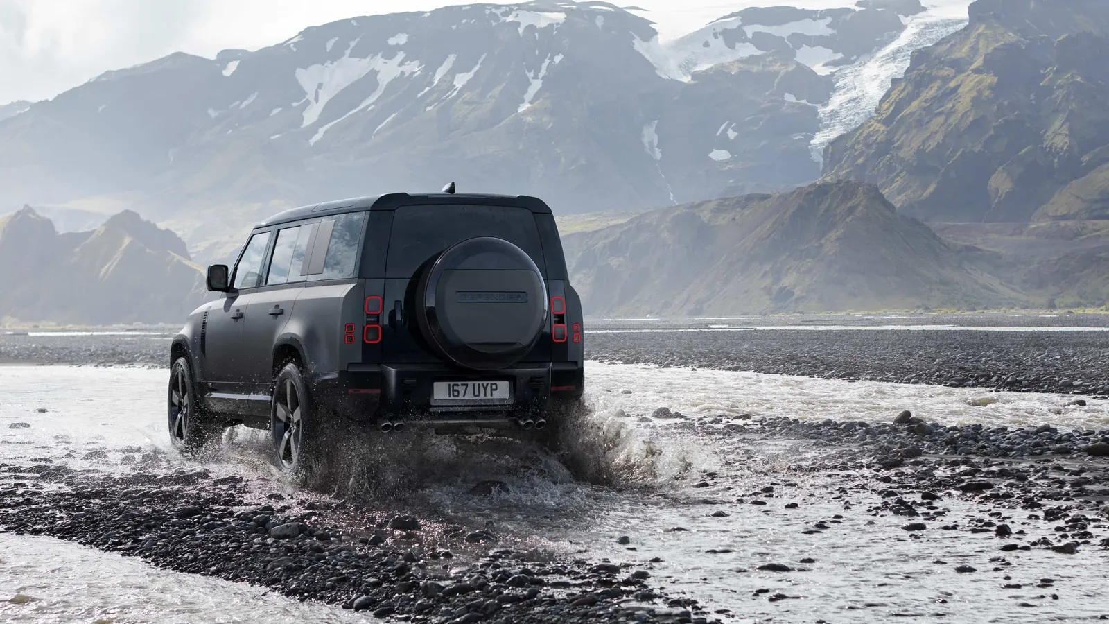 Land Rover Defender 110 crossing a muddy river bed